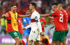 Portugal's Cristiano Ronaldo looks dejected after being eliminated from the World Cup as Morocco players celebrate their win at Al Thumama Stadium, Doha, Qatar, Dec 10, 2022.