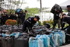 Law enforcement officers arrange bundles of cocaine after drug seizures by the Salvadoran Naval Force on Monday. The UNODC report painted a bleak picture of the worldwide battle against illegal drugs and the criminals behind them.
