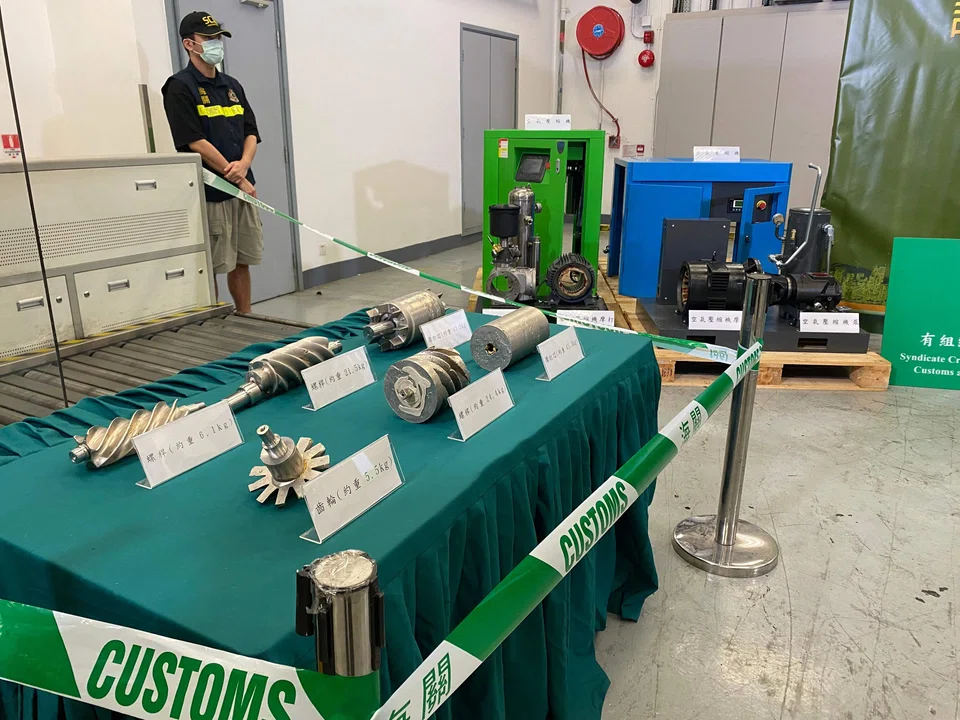 Hong Kong customs officers display smuggled gold after seizing 146 kg of the precious metal disguised as air compressor parts at the city's international airport in Hong Kong on Monday (Apr 8).