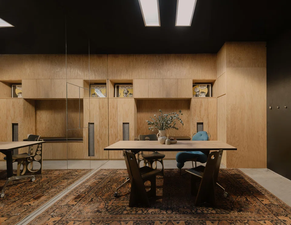 A meeting table is surrounded by vintage chairs.