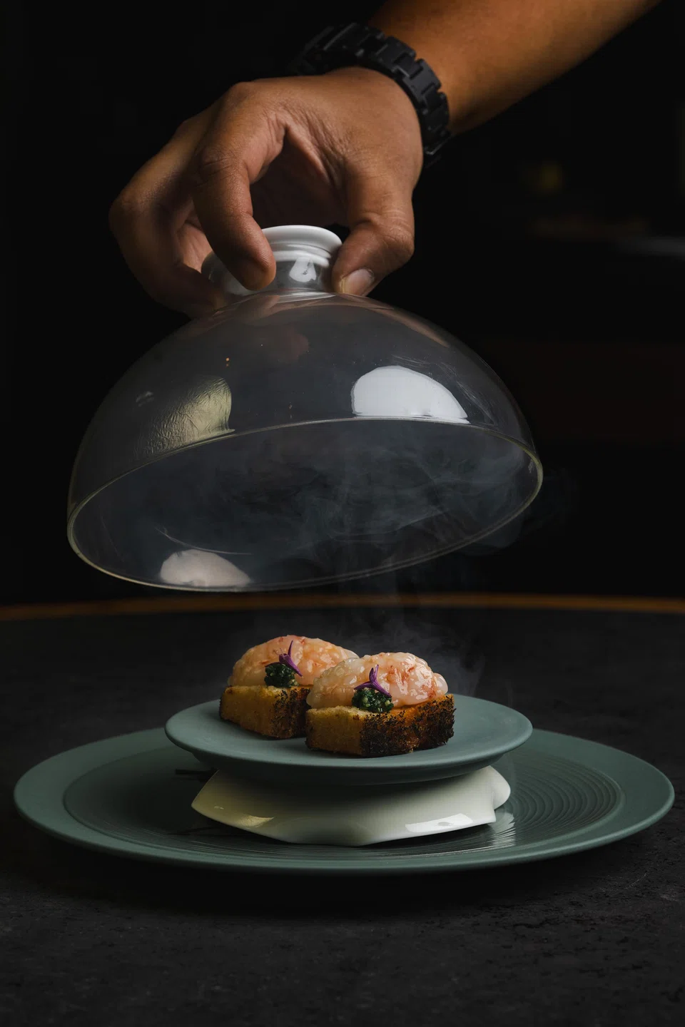 Ama-ebi toast is stuffed with a spicy otah filling and enhanced with a whiff of smoke.