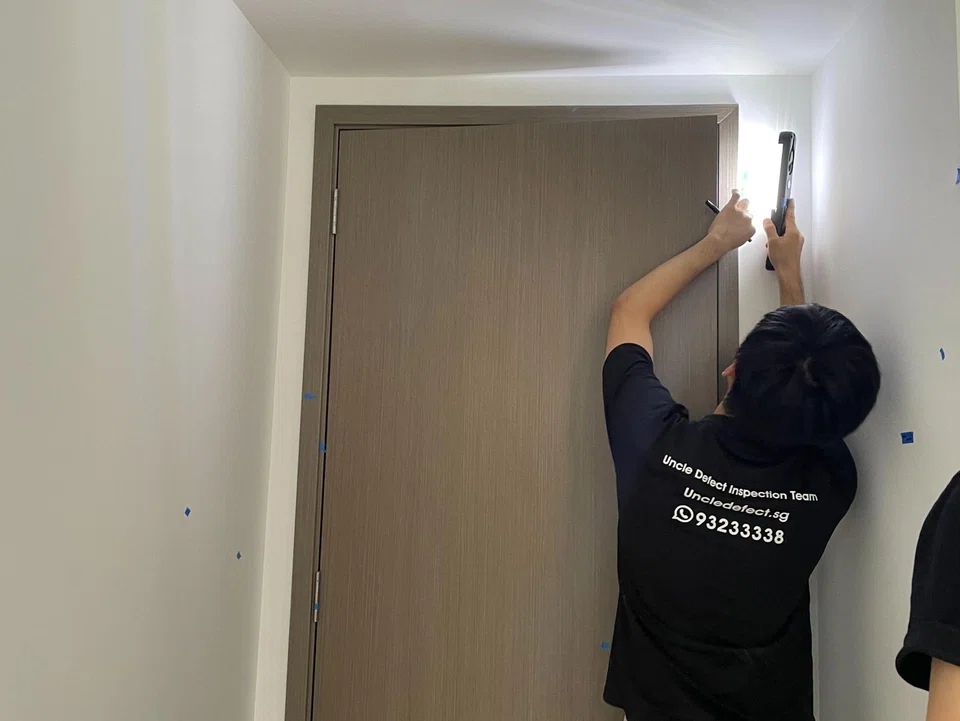 A defect inspector checking for workmanship flaws at a newly completed condo.