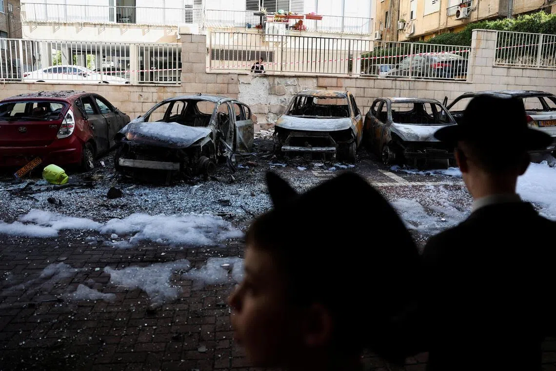 Burnt-out vehicles at an impact site in Petah Tikva, Israel, on Apr 6, following a barrage of missiles launched from Iran.
