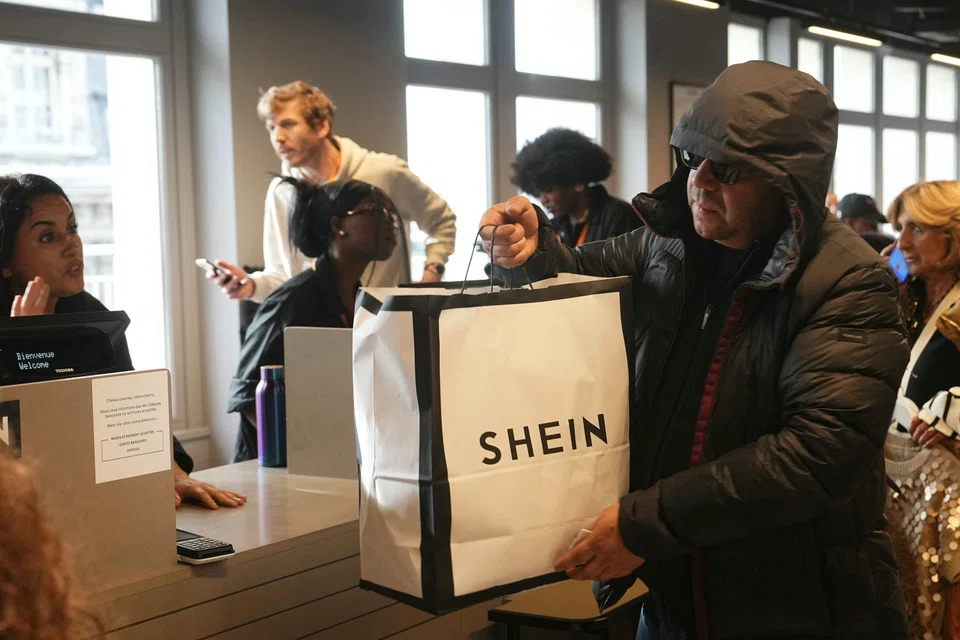 A consumer is about to pay for their items at the checkout on the opening day of Shein's first physical store at the Bazar de l'Hotel de Ville (BHV) department store in Paris on Nov 5.