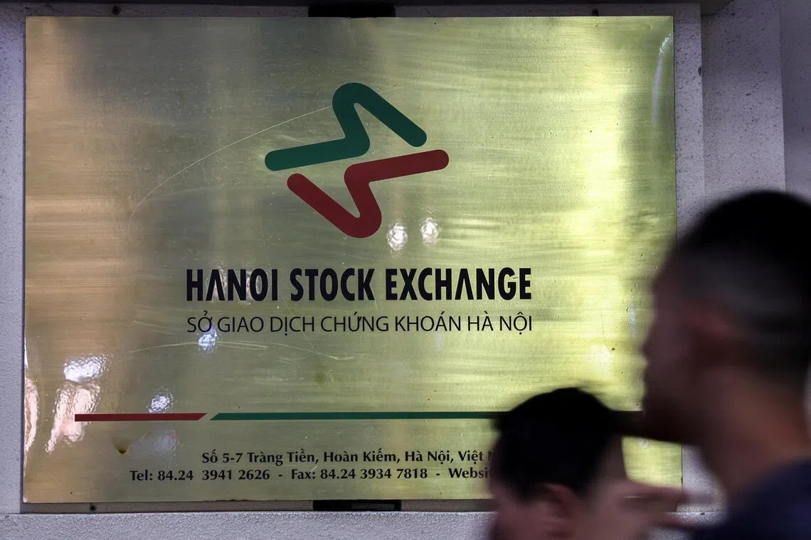 FILE PHOTO: People walk past Hanoi Stock Exchange, after U.S. President Donald Trump announced a 90-day pause on tariffs for many countries, in Hanoi, Vietnam, April 15, 2025. REUTERS/Athit Perawongmetha/File Photo
