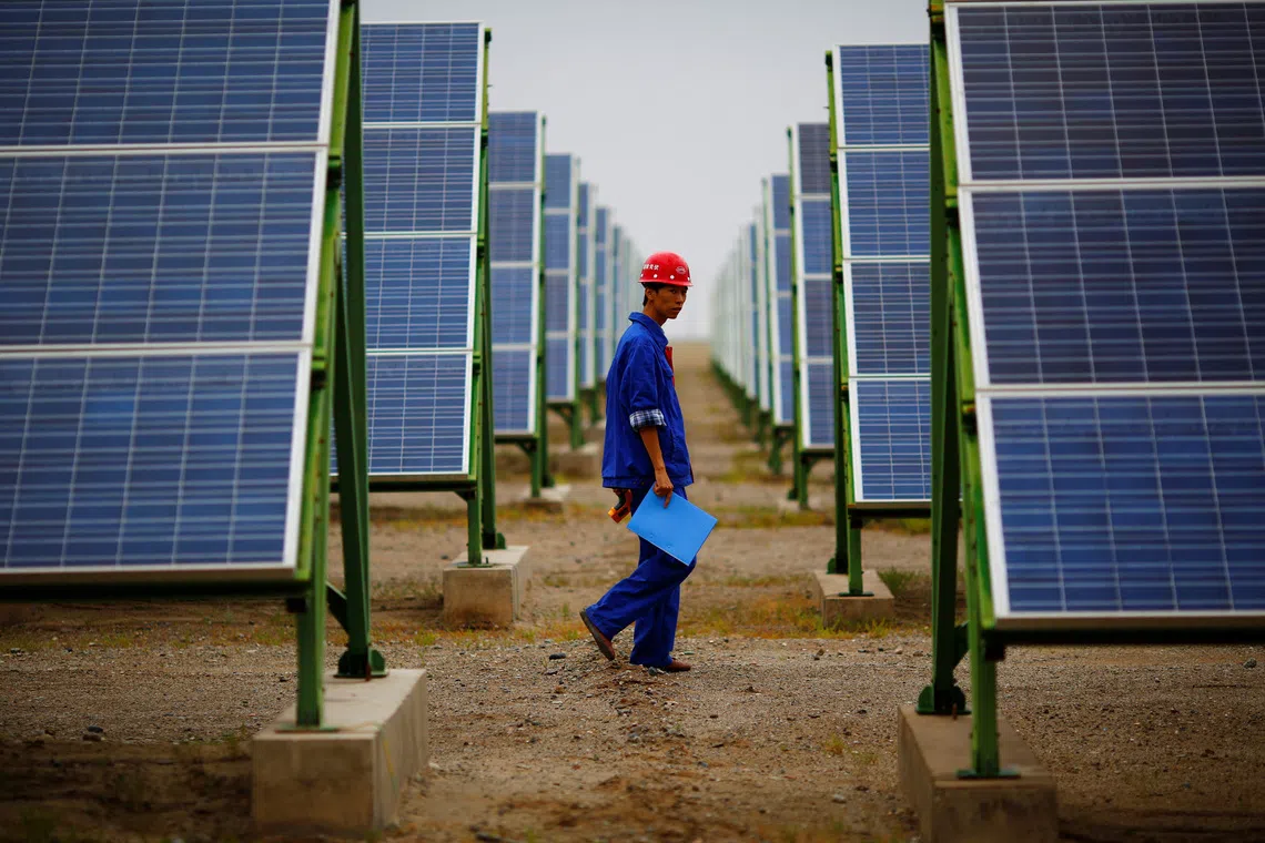 A worker inspects solar panels in Dunhuang, China. The Asean Power Grid presents a strategic opportunity for Chinese clean-energy players, says one expert.