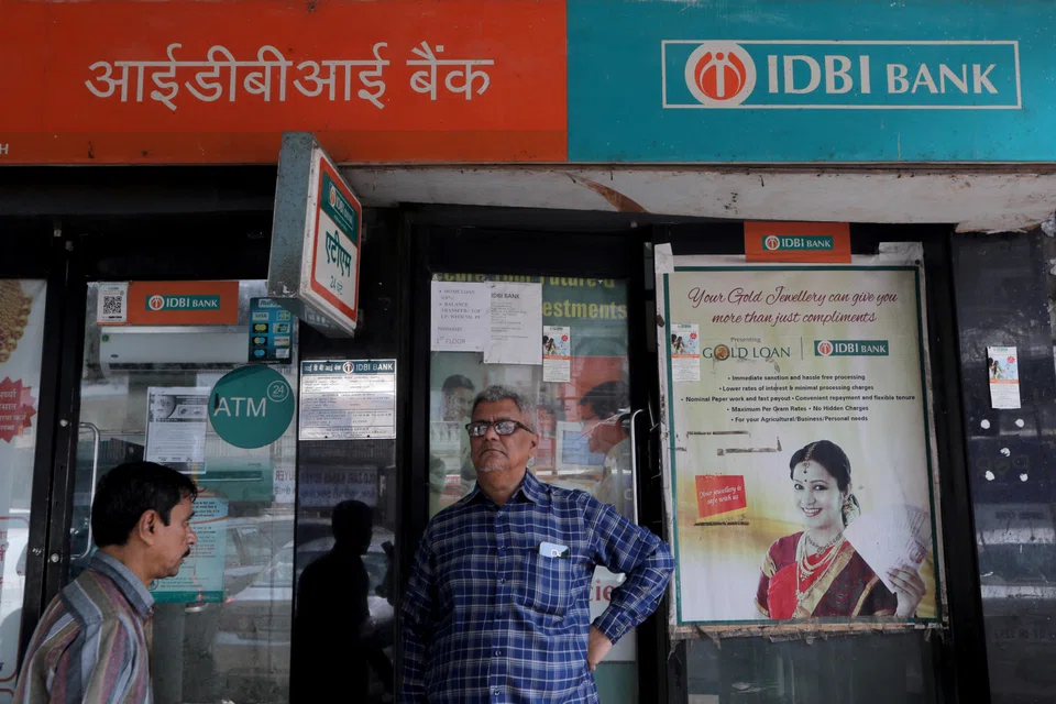 A man stands outside an IDBI Bank branch next to its ATM kiosk in Mumbai. After a record-breaking year in 2021, PE and VC investments totalled US$61.6 billion in 2022.
