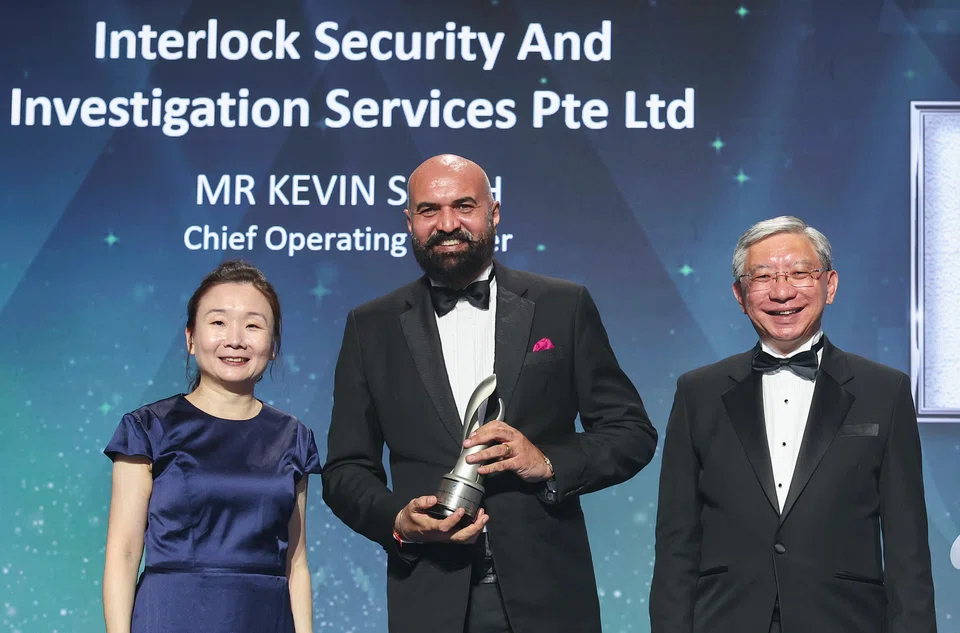 Kevin Singh (middle), chief operating officer of Interlock Security and Investigation Services, was presented with his trophy by Chen Huifen (left), BT editor and co-chair, E50 Awards.
OCBC’s Linus Goh is on the right.