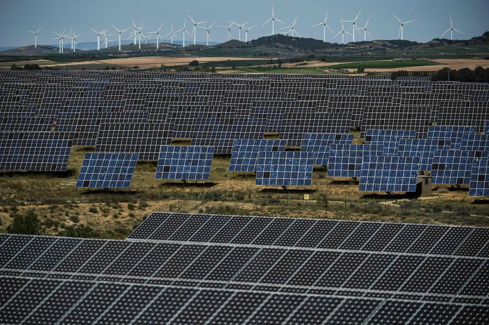 Photovoltaic solar panels and windmills in the background around the Spanish Navarre town of Milagro, April 2023. Europe is under growing pressure to reduce its import dependency in solar panels.