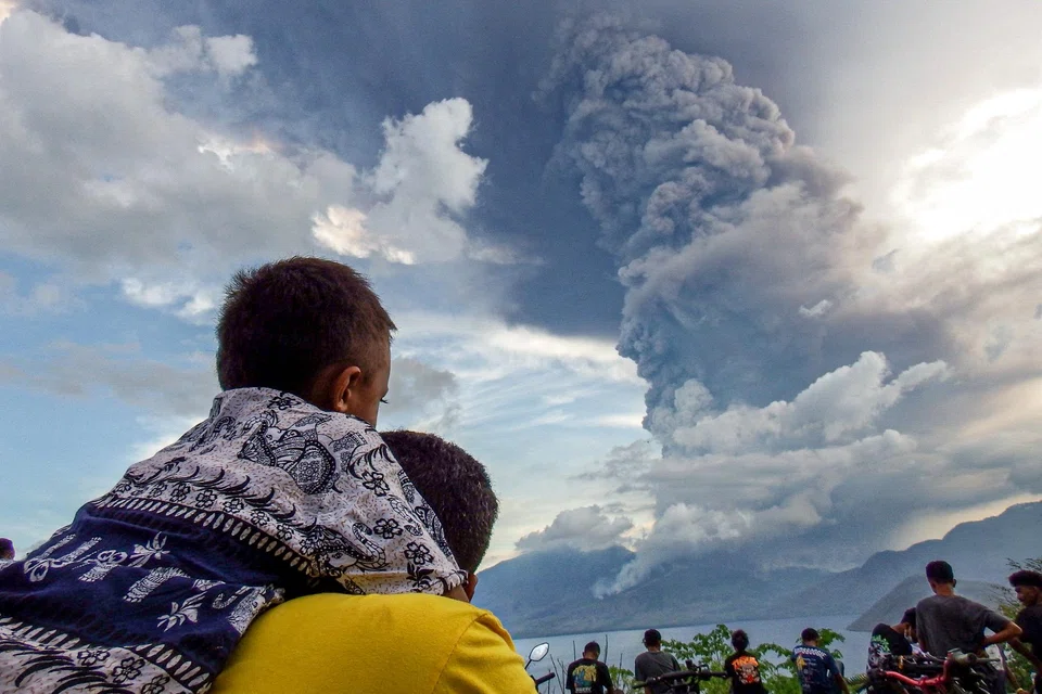 TOPSHOT - Residents watch the eruption of Mount Lewotobi Laki Laki from Eputobi village in Titihena, East Nusa Tenggara, on November 8, 2024. (Photo by Bayu ISMOYO and ARNOLD WELIANTO / AFP)