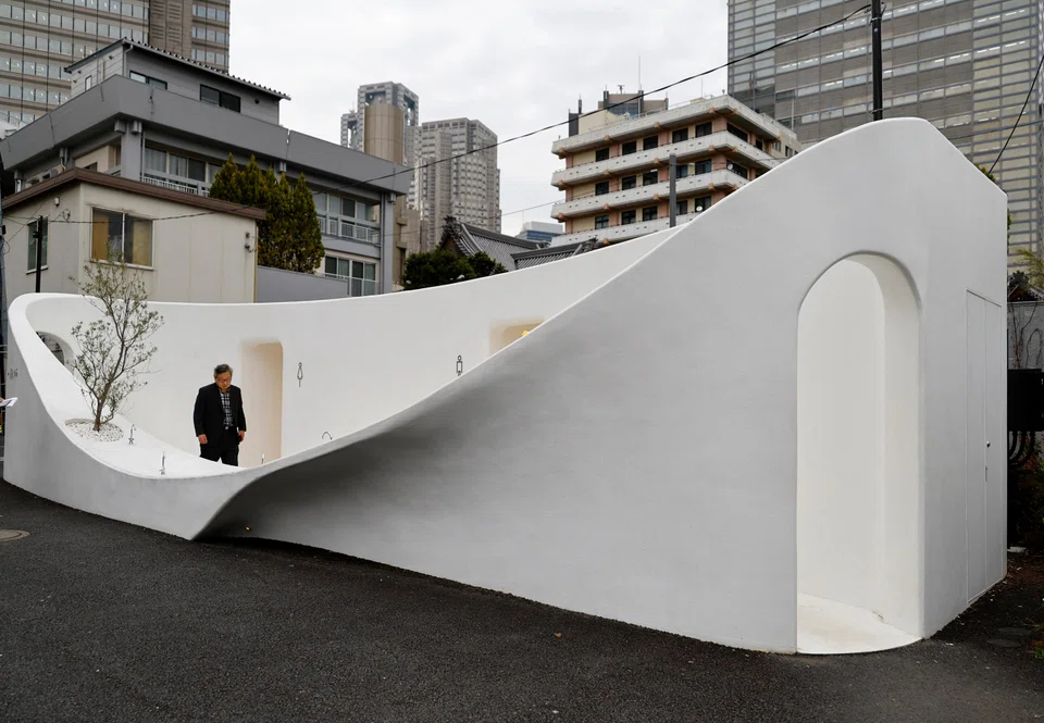 A participant looks around a public toilet which was redesigned as part of a project to transform public toilets into restrooms that can be used comfortably by everyone during a Tokyo Toilet Shuttle Tour at Shibuya ward in Tokyo.