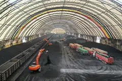 Excavators unloading coal from rail cars into a coal storage facility in Shandong province. Coal accounts for more than half of the electricity generated in China. 