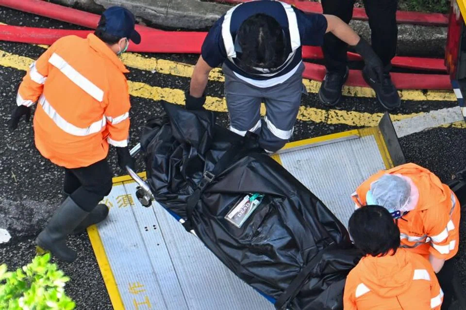 A body is transferred into a vehicle in the aftermath of a major fire that swept through apartment blocks at the Wang Fuk Court residential estate in Hong Kong.