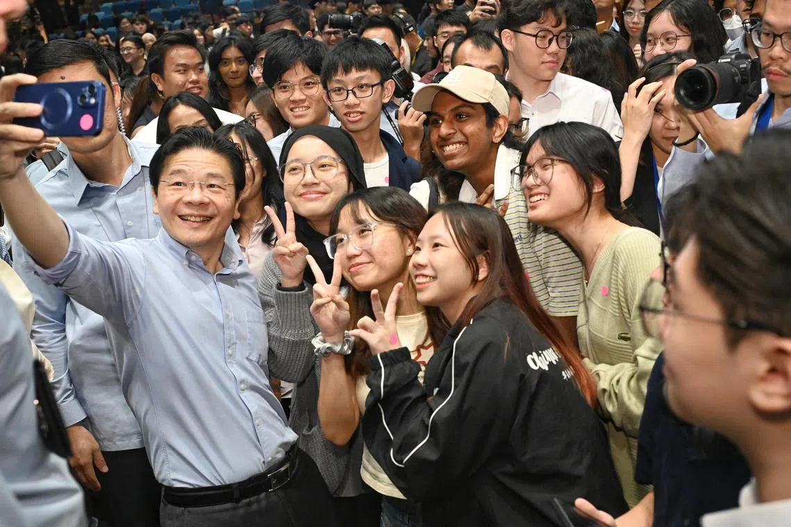 Prime Minister Lawrence Wong takes a wefie with students from institutes of higher learning at a dialogue held by the Institute of Policy Studies and student-led inter-university group Varsity Voices.