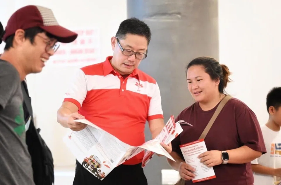 Lawrence Pek (centre) mingling with a resident at the Plantation Plaza in Tengah on Mar 29.