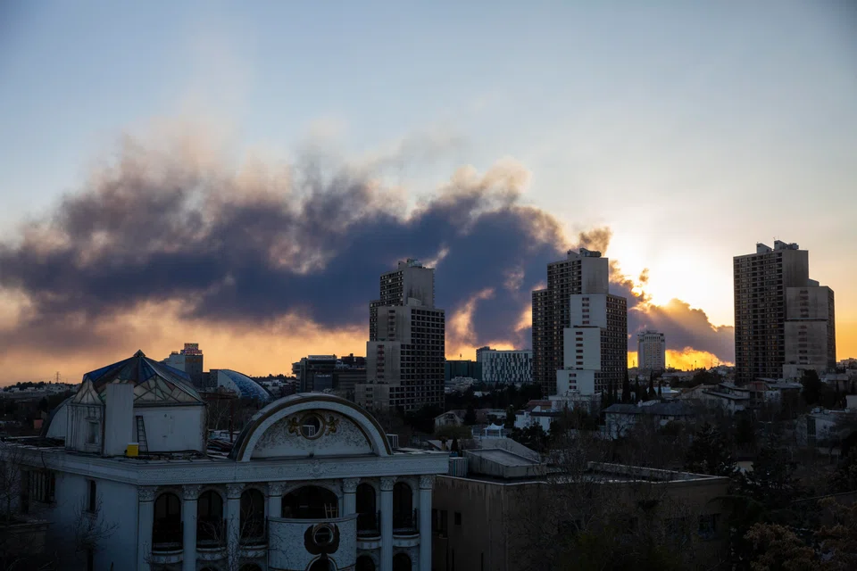 The sun sets as a cloud of smoke from airstrikes blankets the sky in Teheran, Iran, March 3, 2026. 