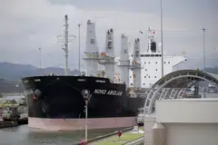 A ship transits through the Miraflores locks in the Panama Canal. The waterway is experiencing its worst drought in 70 years, leading to a backlog of vessels and long waiting periods.