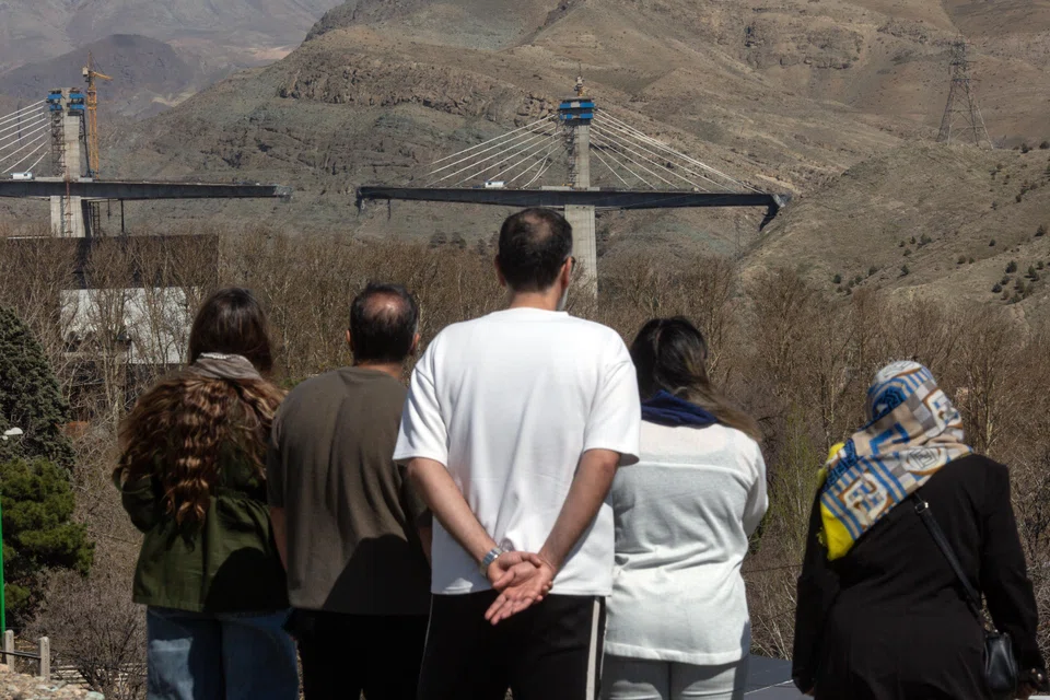 People view the damage to a major highway bridge near Karaj in Iran on Friday (Apr 3) after an American airstrike caused its partial collapse. 
