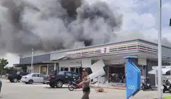 Smoke billowing from the roof of a convenience store near a petrol station in Sisaket, Thailand after it was hit by a rocket strike from Cambodia. 