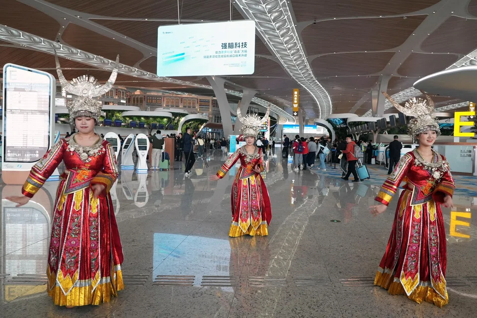 Performers in ethnic costumes dance at the Guangzhou Baiyun International Airport, as the Spring Festival travel rush begins on Monday (Feb 2) ahead of the Chinese New Year.