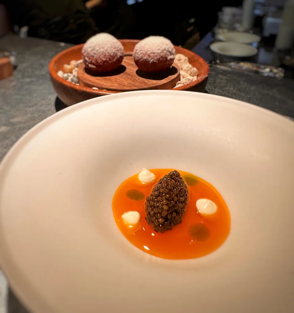 Caviar is layered with an egg yolk sauce and creme fraiche, served with brioche buns.