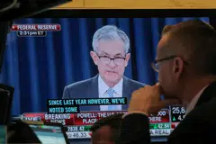 A trader watches US Federal Reserve chairman Jerome Powell on a screen during a news conference. Powell has warned that the Fed will continue tightening monetary policy if needed.