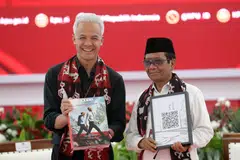 Ganjar Pranowo (left) has named Mahfud MD, a current law and security chief minister, as his running mate. 