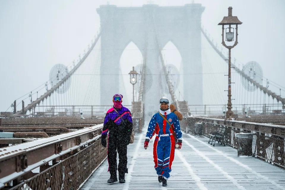 Pedestrians walk during a winter storm in the Brooklyn borough of New York, New York, Jan 25, 2026. 