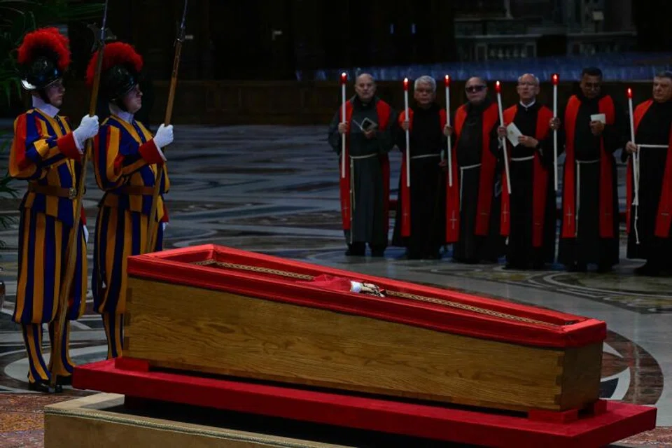 Swiss guards (L) and members of the clergy (Top R) stand next to the coffin of the late Pope Francis (C) inside St Peter's Basilica.