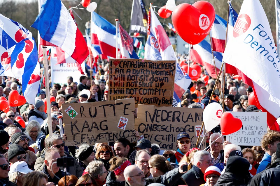 Dutch farmers holding banners and flags protest against government policies to limit nitrogen emissions in The Hague, Netherlands Mar 11, 2023.