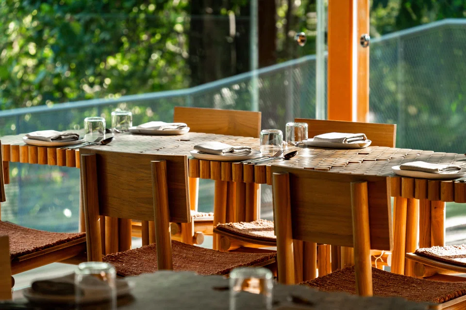AIR's dining room is furnished with tables and chairs made of recycled wood.