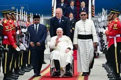 Pope Francis (centre, in wheelchair) is welcomed during his arrival at Soekarno–Hatta International Airport in Jakarta on Sep 3, 2024. .