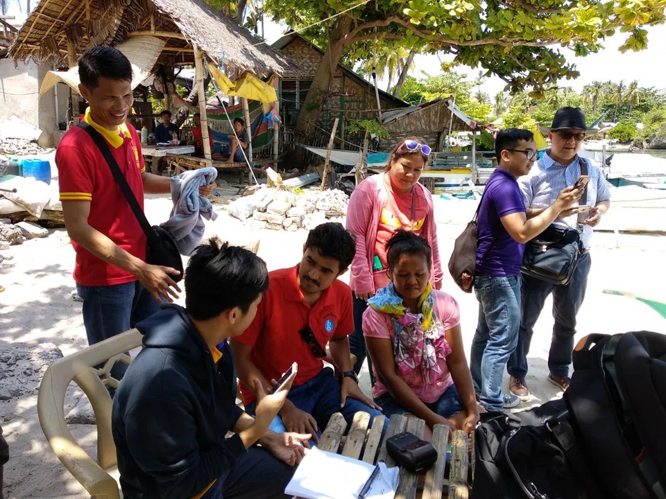 Villagers in the Philippines being introduced to Bank-Genie's financial services.
