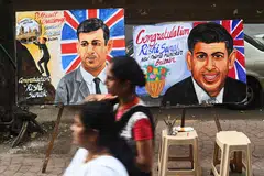 Pedestrians walk past paintings of new Conservative Party leader and incoming British prime minister Rishi Sunak in Mumbai on Oct 25, 2022. Sunak on Thursday told his Indian counterpart Narendra Modi he “hoped” they could agree a trade pact, Downing Street said.