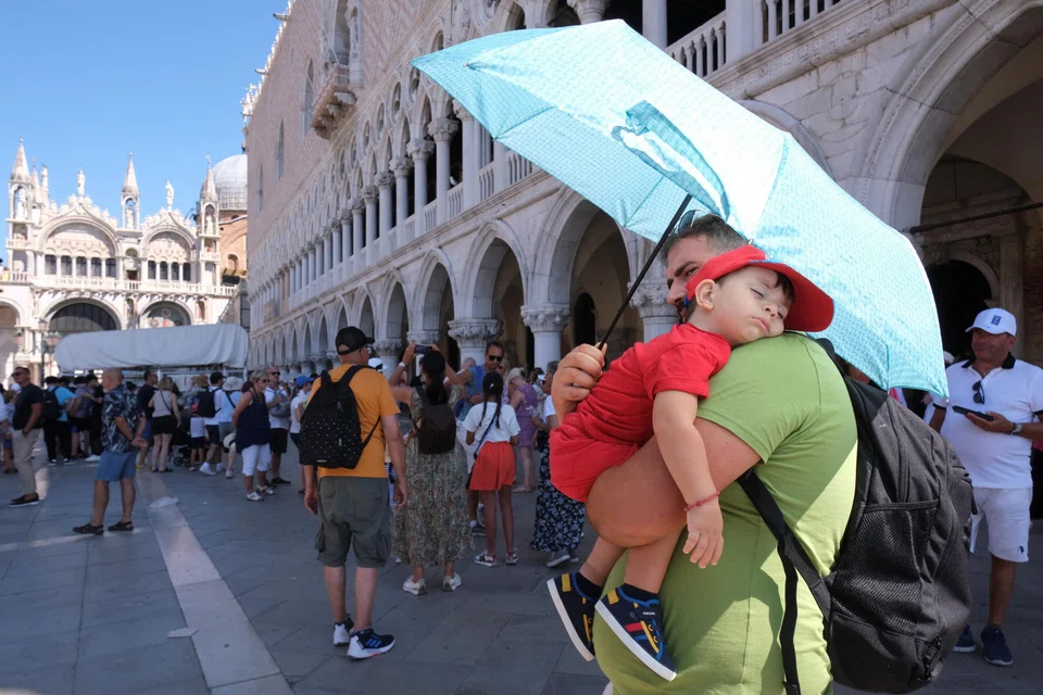 Tourists walk during a heatwave as temperatures are expected to reach 40 deg C in some cities, in Venice, Italy, Aug 10, 2024. 