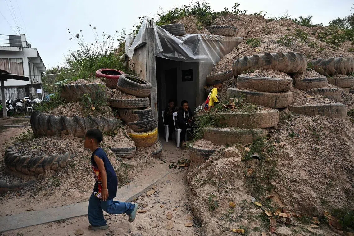Children playing around a bunker in Surin province, Thailand. Hundreds of thousands of people living close to the border have been displaced by the clashes.