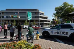 People watch as Springfield Police Department officers investigate the Springfield City Hall after bomb threats were made against buildings earlier in the day in Springfield, Ohio, Sept 12, 2024. 