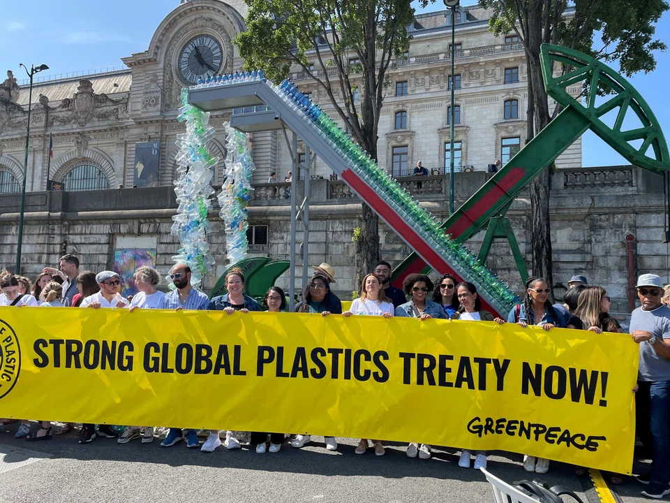Actor Shailene Woodley and activists hold a banner as Greenpeace International unveils an art installation by artist Benjamin Von Wong, ahead of a four-day summit of the UN Environment Programme on reducing plastic pollution, Paris, France, May 27, 2023. 