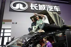 American YouTuber Ethan Robertson, 34, sits on a Great Wall Motor Hi4-T off-road vehicle as he brings foreign visitors to tour the Beijing Auto Show.