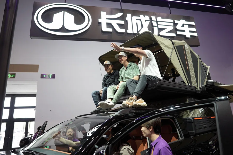 American YouTuber Ethan Robertson, 34, sits on a Great Wall Motor Hi4-T off-road vehicle as he brings foreign visitors to tour the Beijing Auto Show.