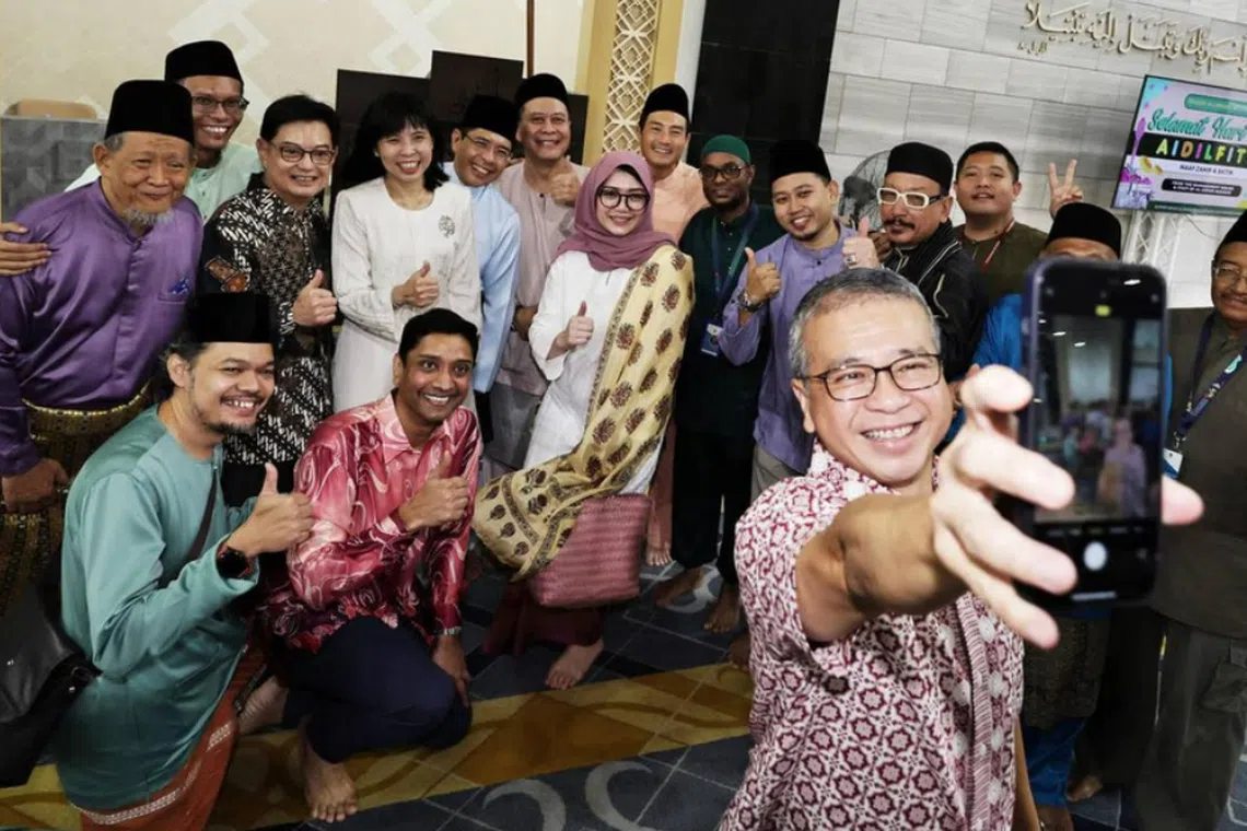 Minister Edwin Tong taking a wefie with (back row; third, fourth and fifth from left) DPM Heng Swee Keat, MP Jessica Tan and Minister Maliki Osman, Senior Minister of State for National Development Tan Kiat How (in orange) as well as (front row; second and third from left) Dinesh Vasu Dash,  Hazlina Abdul Halim and congregation members, at Al-Ansar Mosque on March 31.