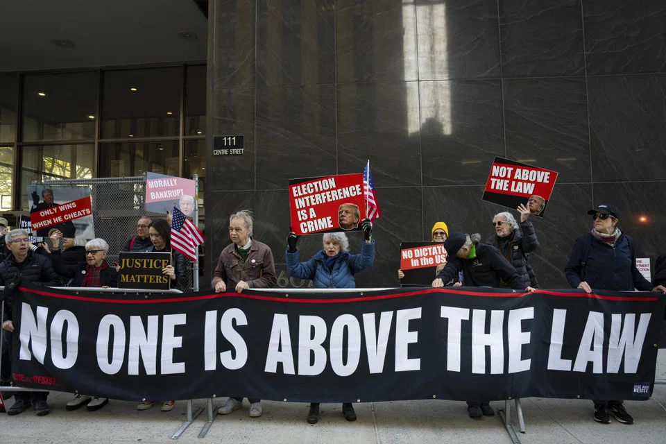 Protesters hold a banner reading “no one is above the law” outside former President Donald Trump's criminal trial at Manhattan Criminal Court in Manhattan, April 22, 2024. 