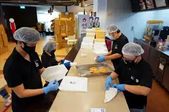 The Social Kitchen hired people from the vulnerable community to wrap 50,000 plant-based burgers for distribution to frontline workers and the community in 2021. 