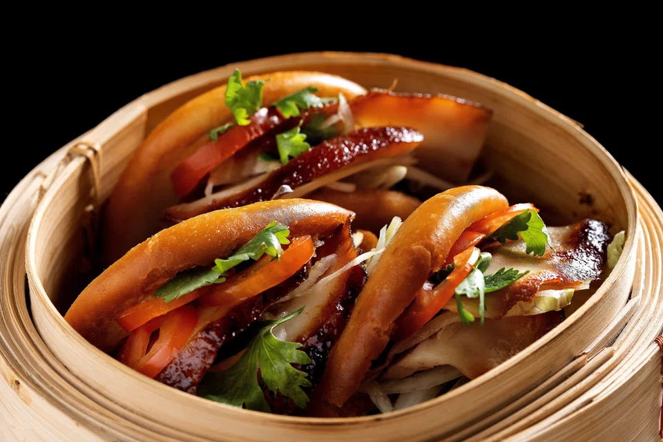 Deep fried mantou buns are stuffed with fatty iberico pork and pickles.