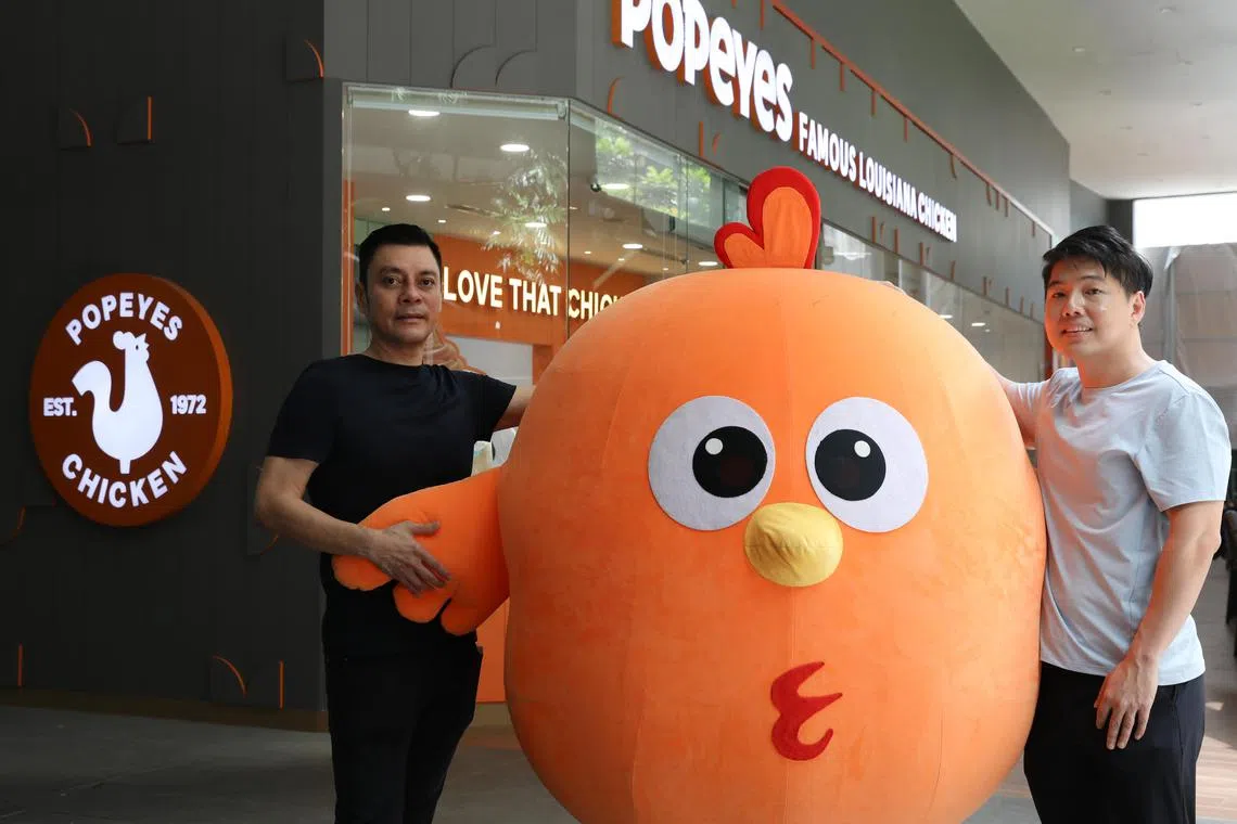 Tan Kim Siong, founder and chairman of Fei Siong Group (left), with Jedrick Tan, chief strategy officer of Fei Siong, at the Popeyes Singapore outlet in Somerset.