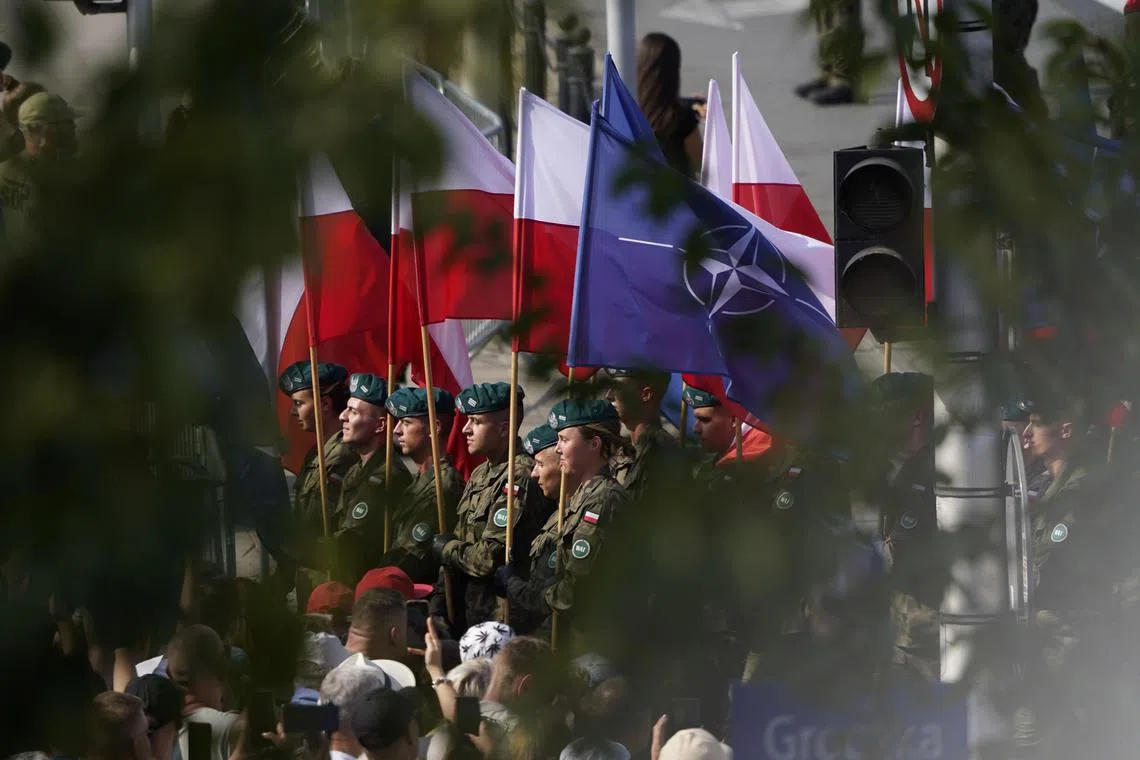 The flags of Poland and Nato at the Polish Army Day parade in Warsaw on Aug 15. Countries in Europe do more than two-thirds of their military procurement in the US, starving European companies of much-needed investment. 
