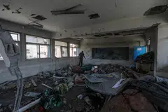  Palestinians inspect the damage at a destroyed UNRWA school building following an Israeli airstrike in Al Nusairat refugee camp in the central Gaza Strip.