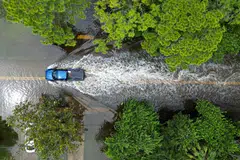 An aerial view shows a vehicle driving along a flooded street in New Port Richey, Florida, on August 30, 2023, after Hurricane Idalia made landfall.