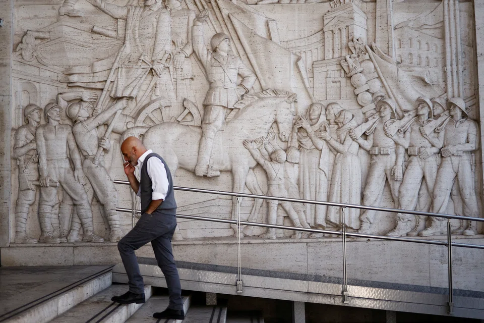 A man walks past a bas-relief depicting fascist leader Benito Mussolini at the Eur neighbourhood known for its fascist architecture in Rome on Oct 19.