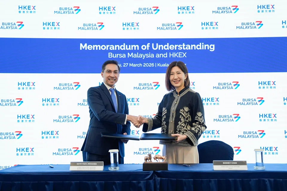 Bursa Malaysia CEO Fad’l Mohamed (left) and HKEX CEO Bonnie Chan exchange MOU documents at Bursa Malaysia.